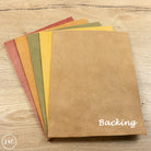 Set of brown paper sheets on a wooden surface with 'Backing' text.