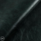 Close-up of dark green leather fabric with visible texture