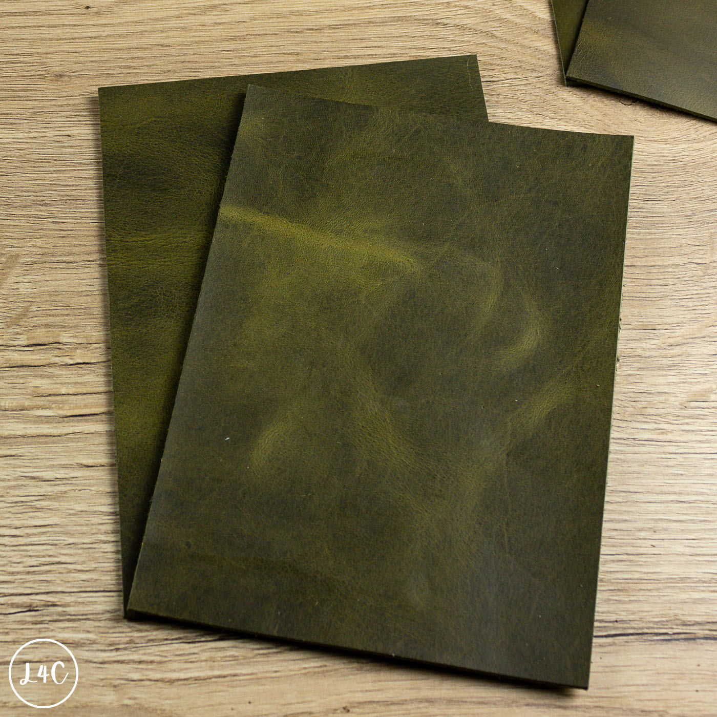 Two green leather panels on a wooden surface