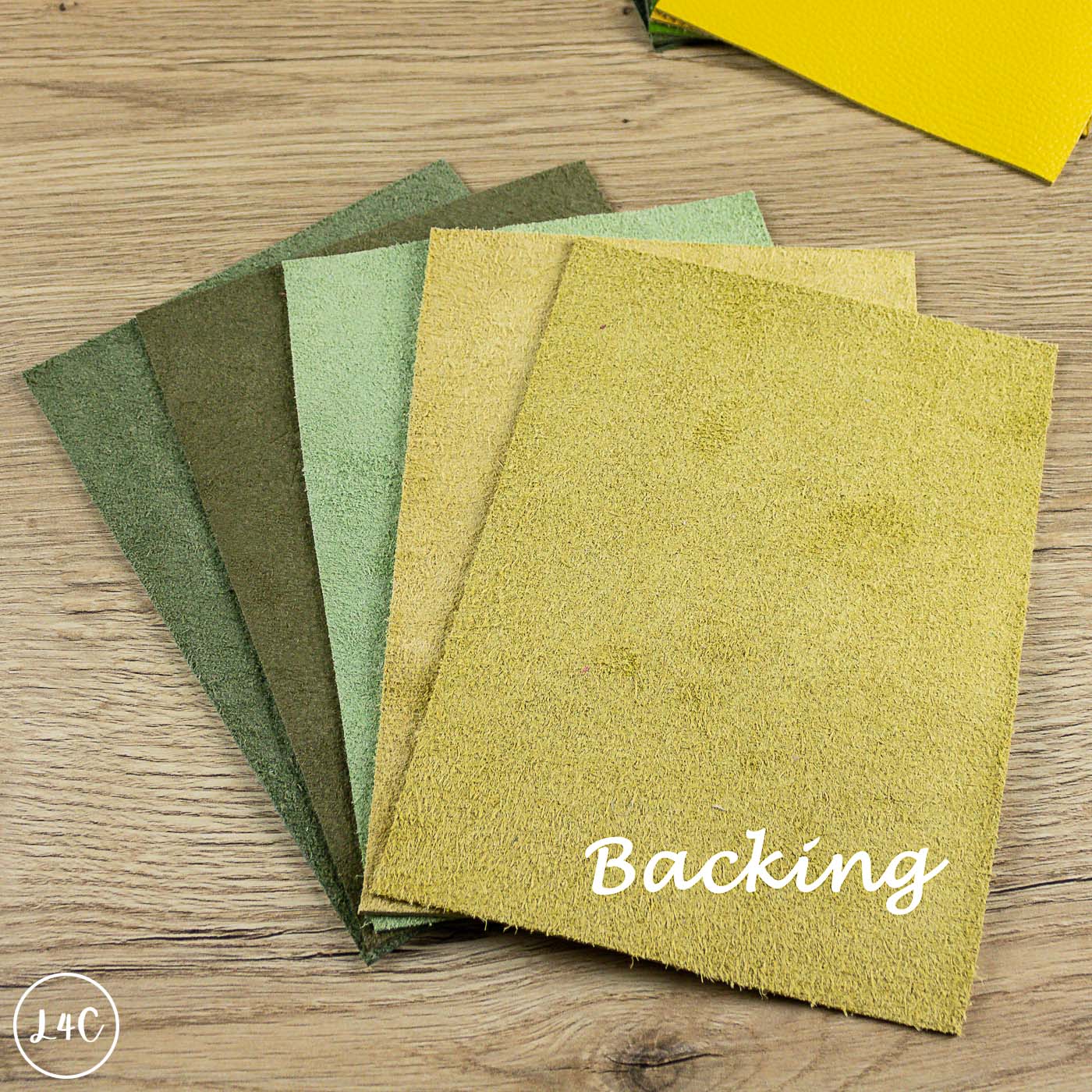 Collection of leather with 'Backing' text on a wooden surface
