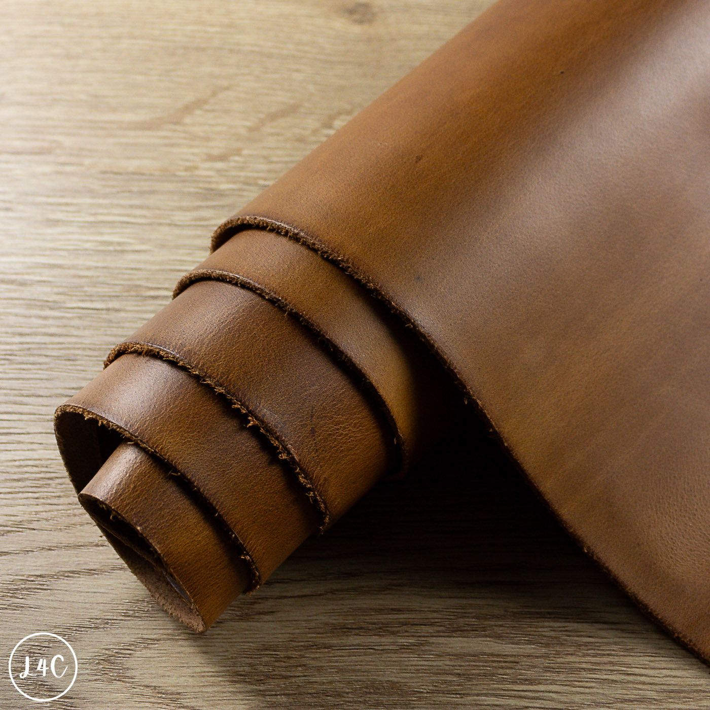 Rolled-up brown leather on a wooden surface