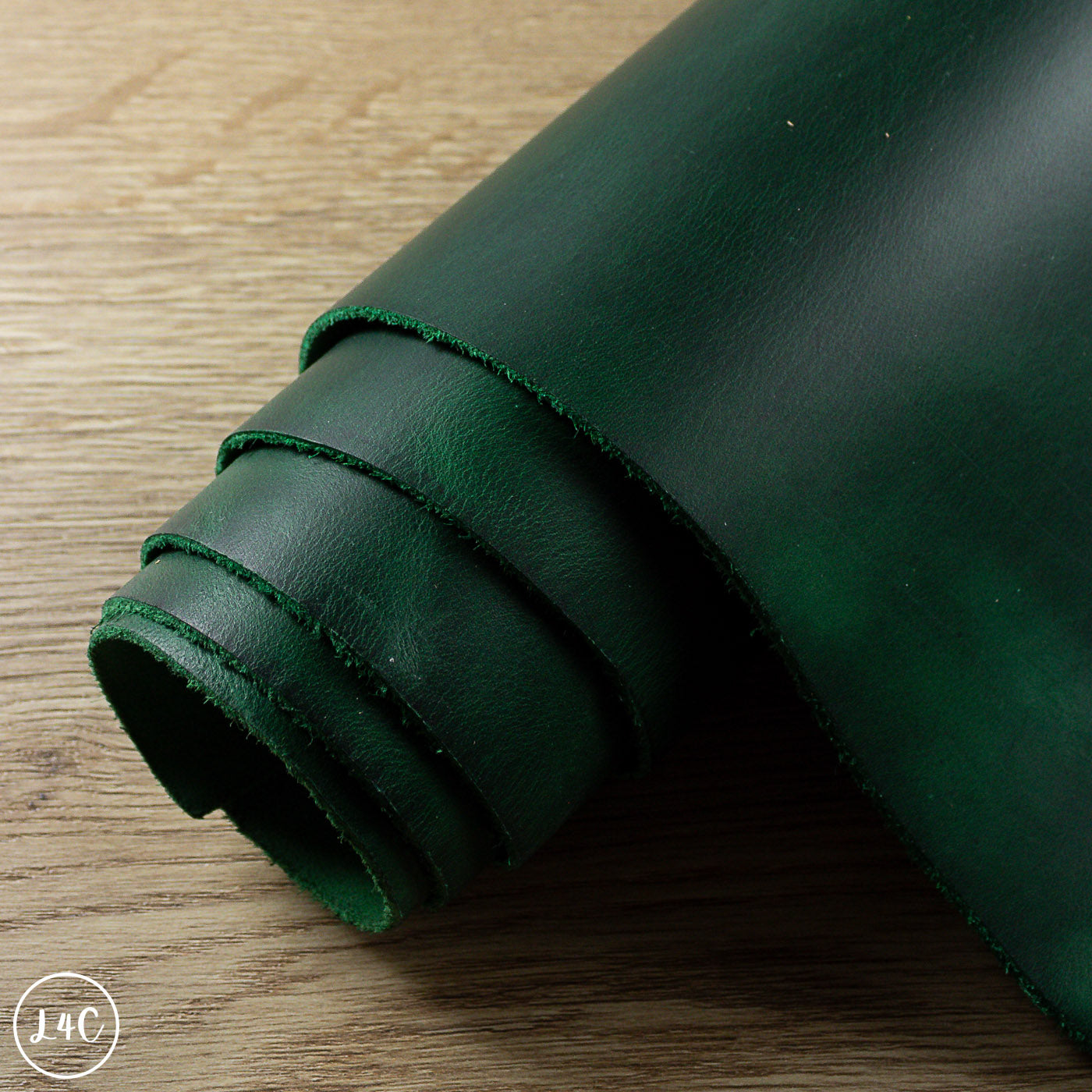 Rolled-up green leather on a wooden surface