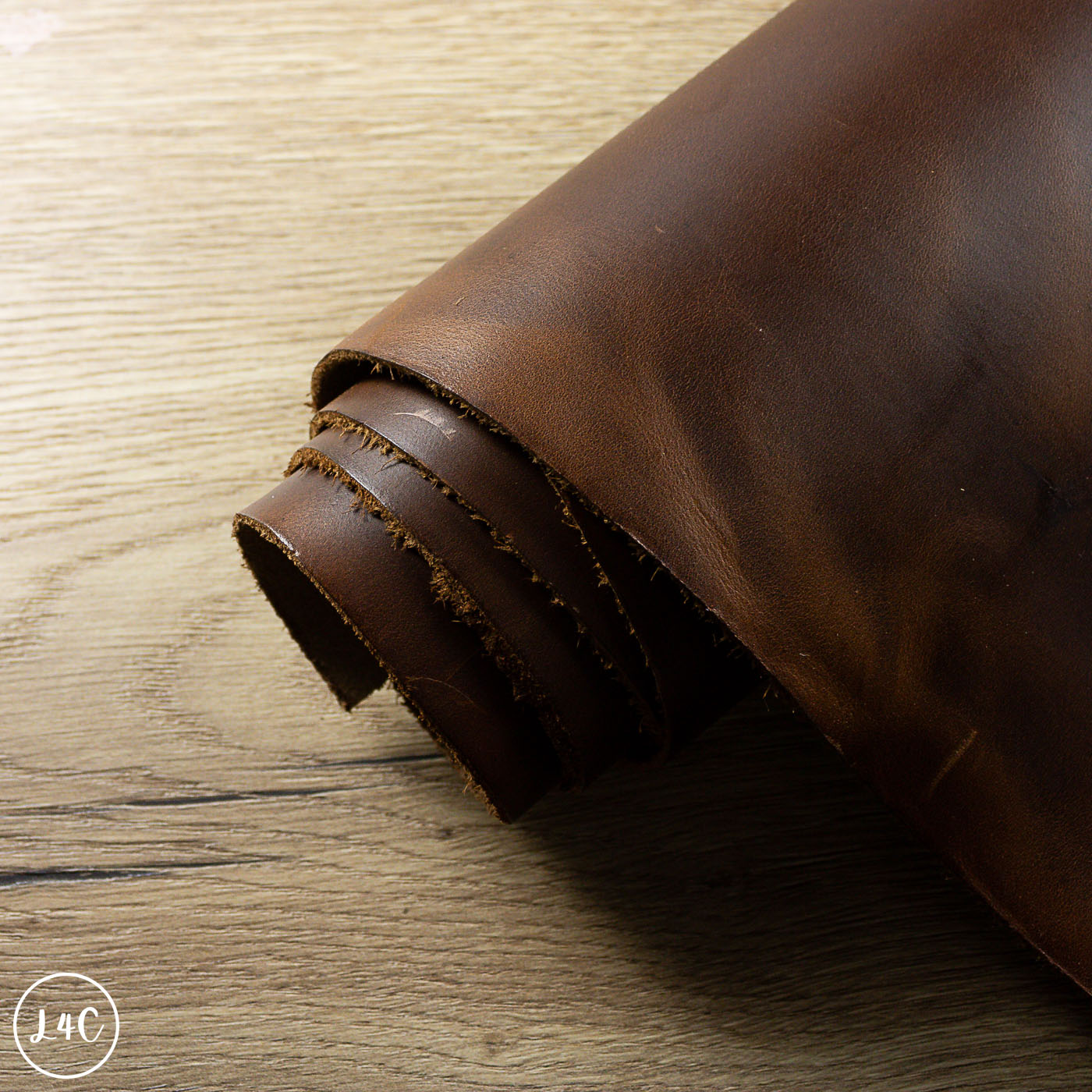 Rolled-up piece of brown leather on a wooden surface