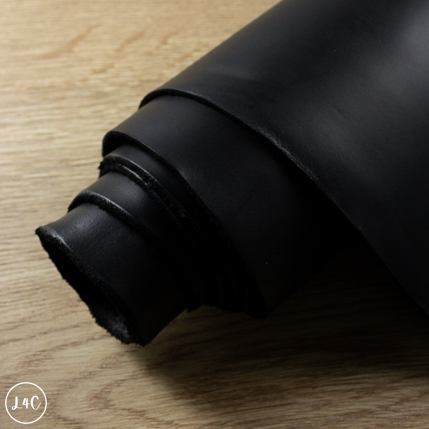 Rolled-up black leather on a wooden surface