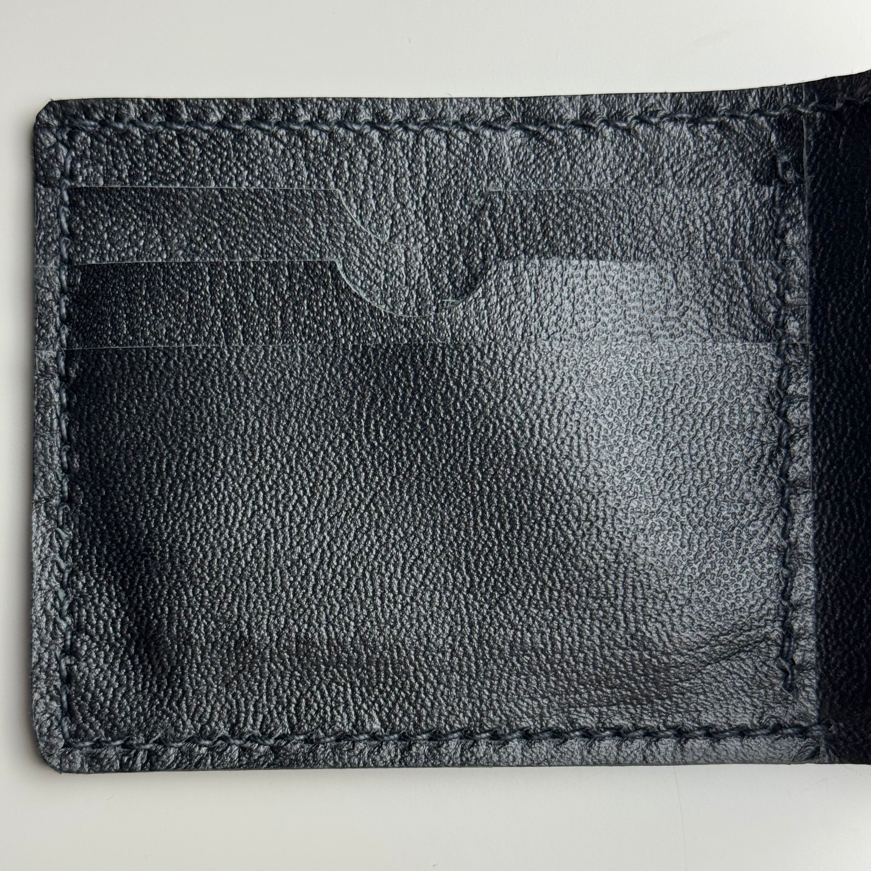 Close-up of a black leather wallet on a light gray background