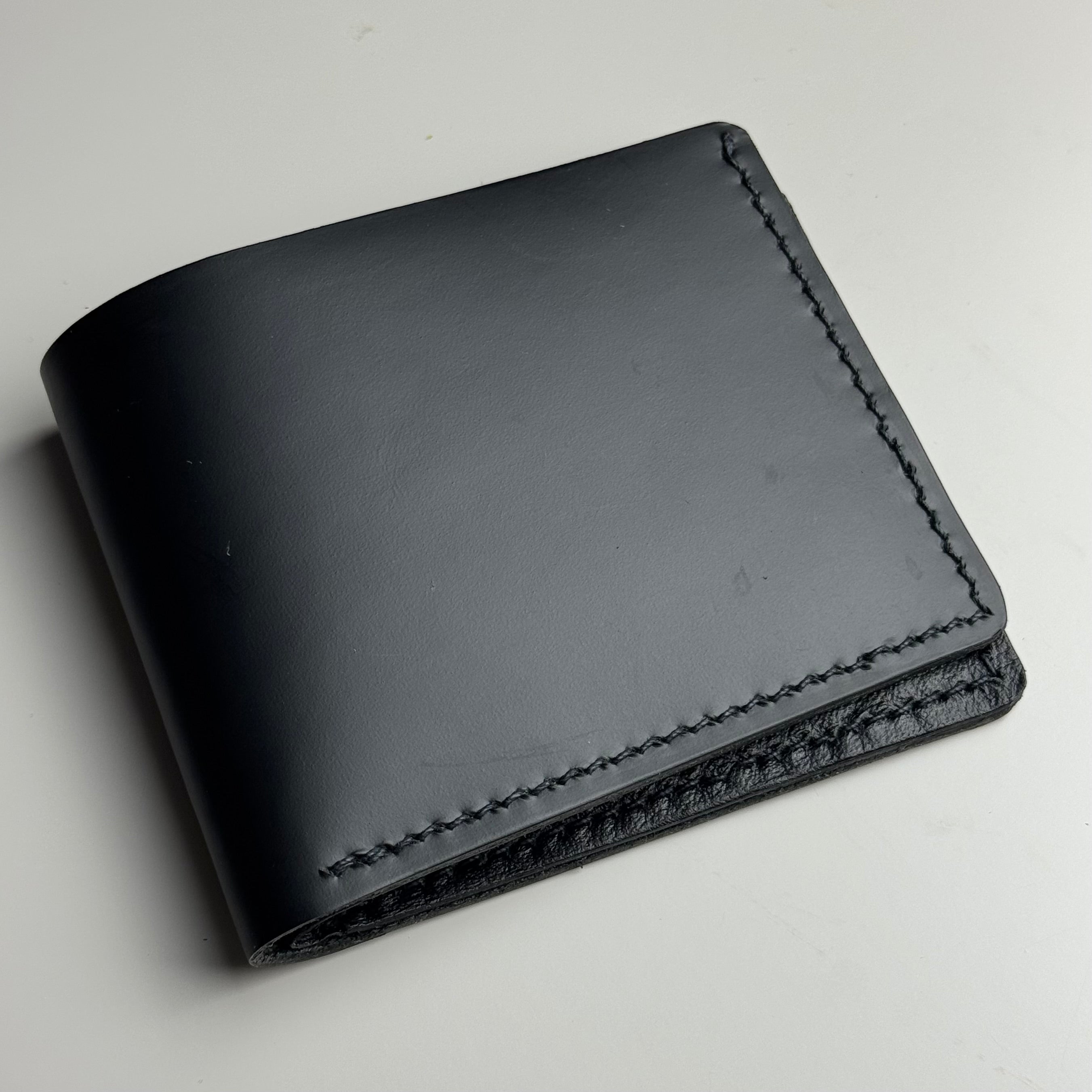 Black leather wallet on a light gray background