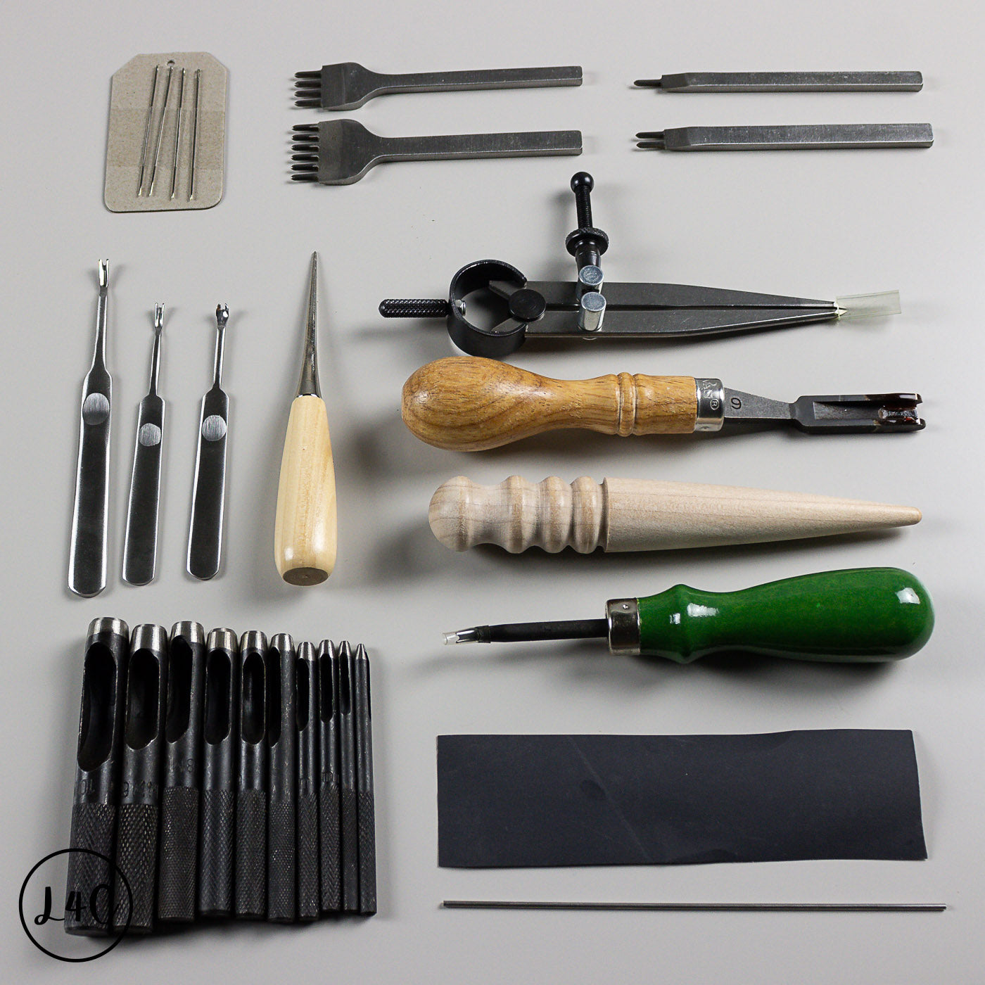 Collection of leatherworking tools on a gray background