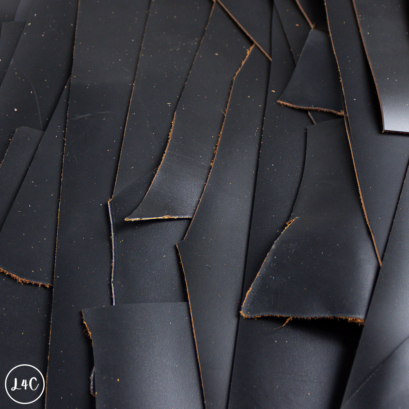 Scattered pieces of black leather on a dark background