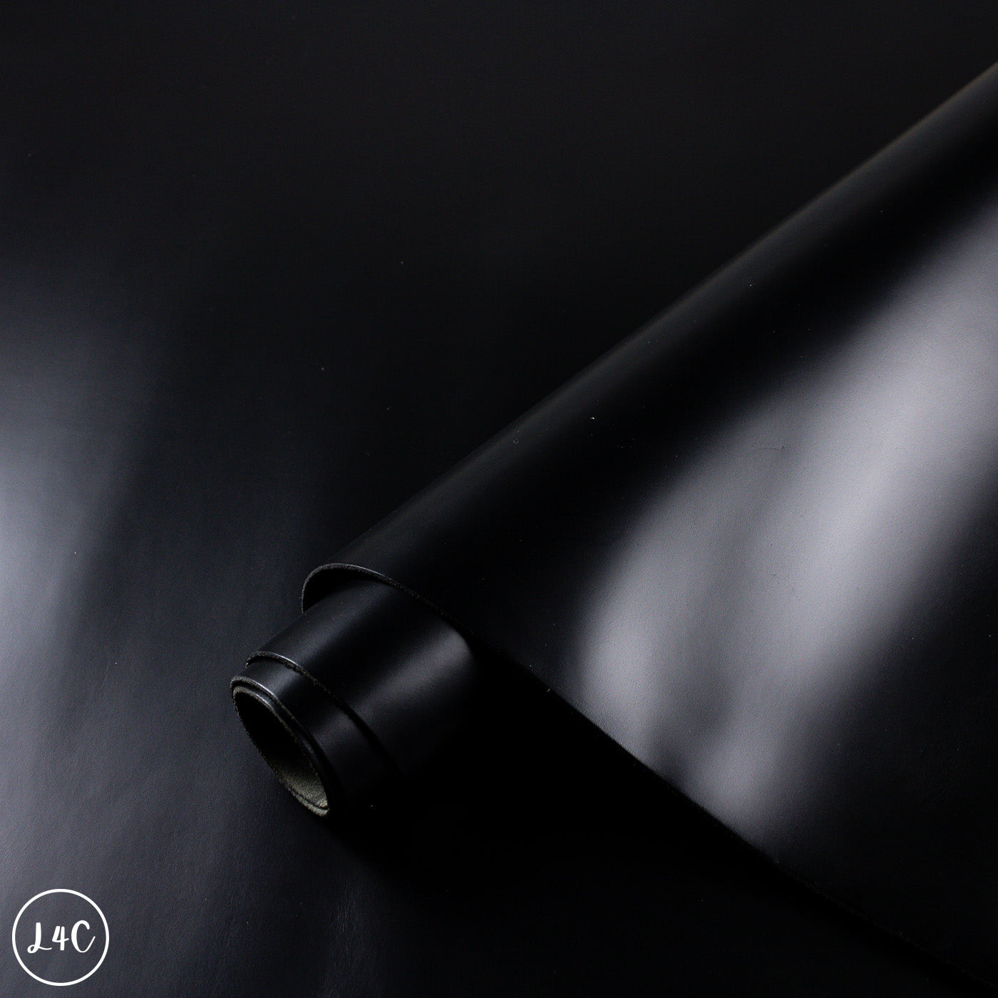 Roll of black leather on a dark background