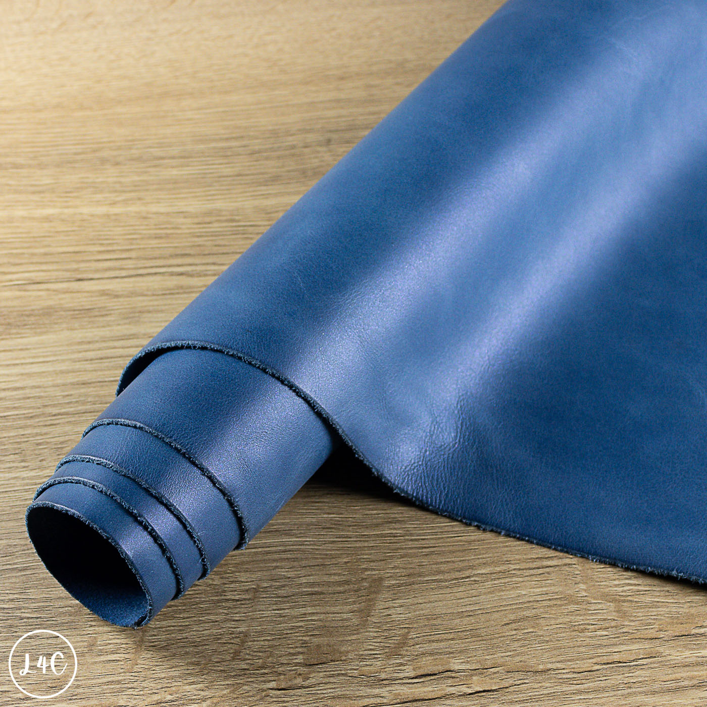 Rolled-up blue leather sheet on a wooden surface