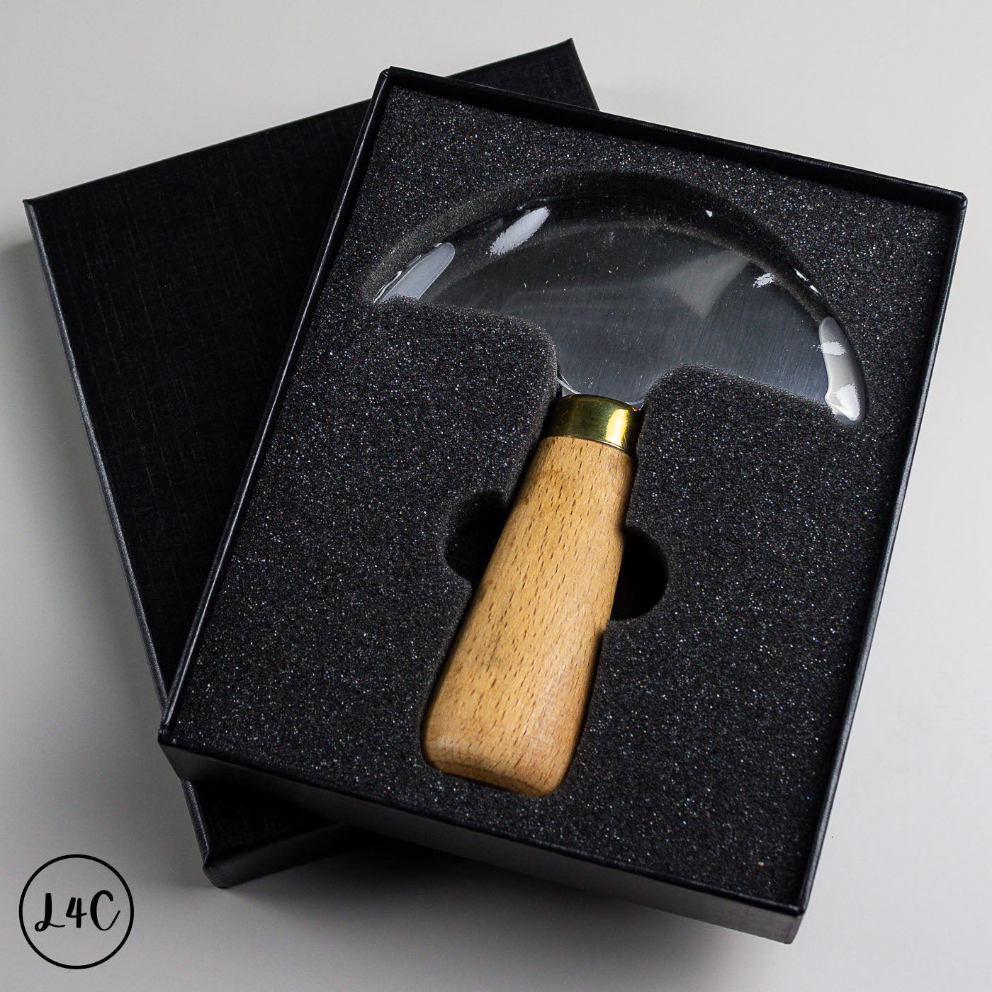 leather tool with wooden handle and metal head in a black box