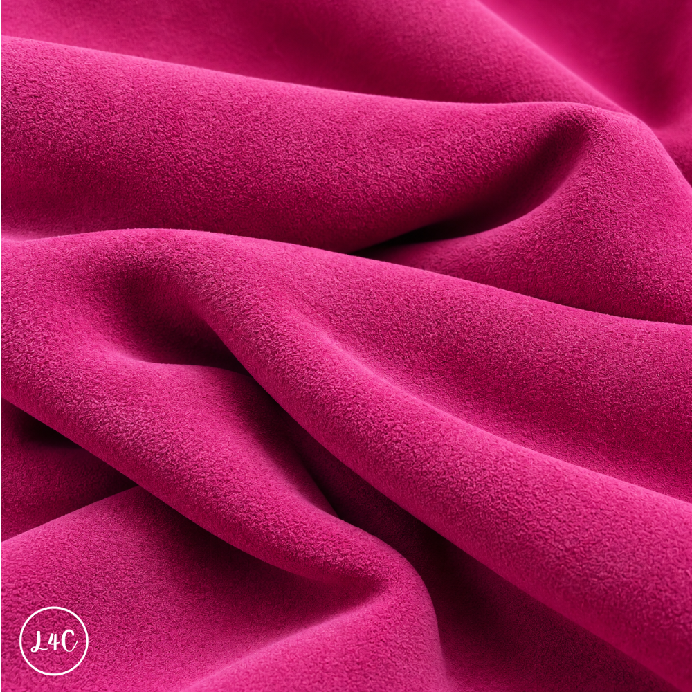 A close-up of draped dark pink suede leather with a soft, plush texture, showing deep folds and shadows.
