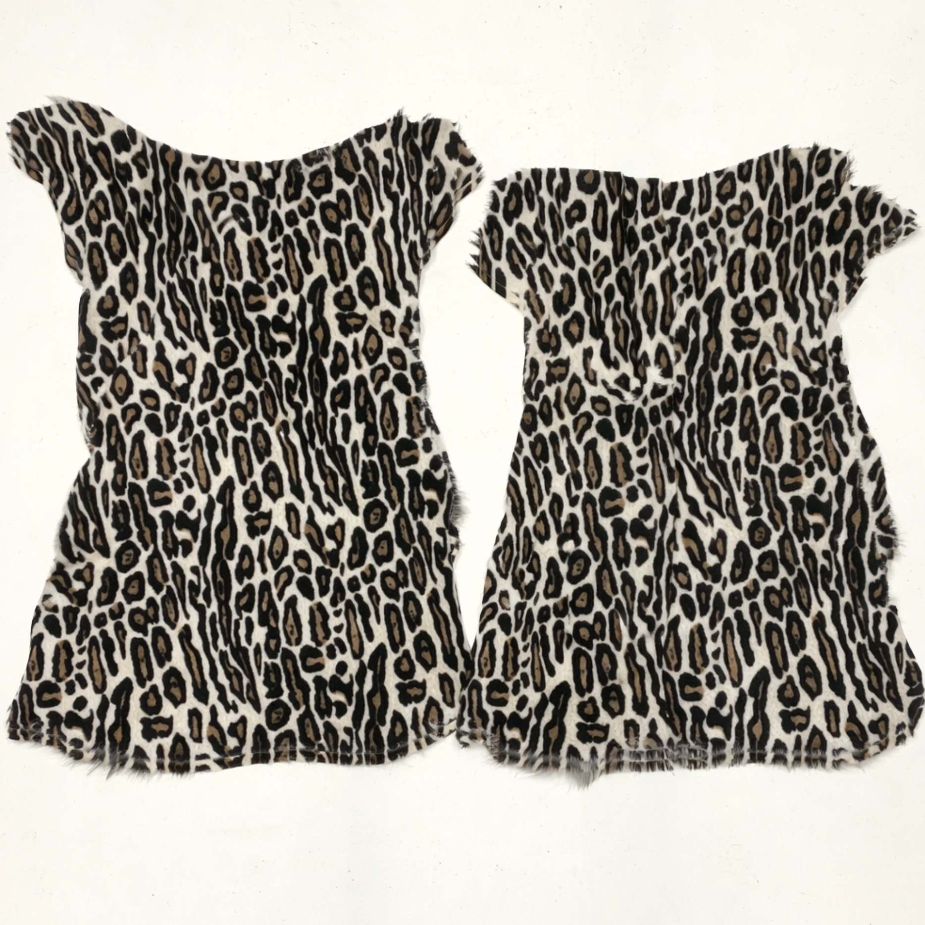 Two snow leopard print hides on a white background