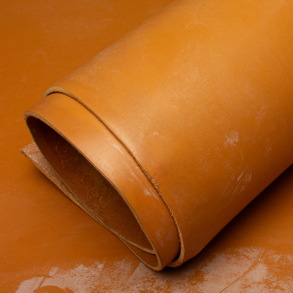 Rolled-up piece of brown leather on a textured surface