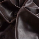 Close-up of dark brown leather fabric with visible texture