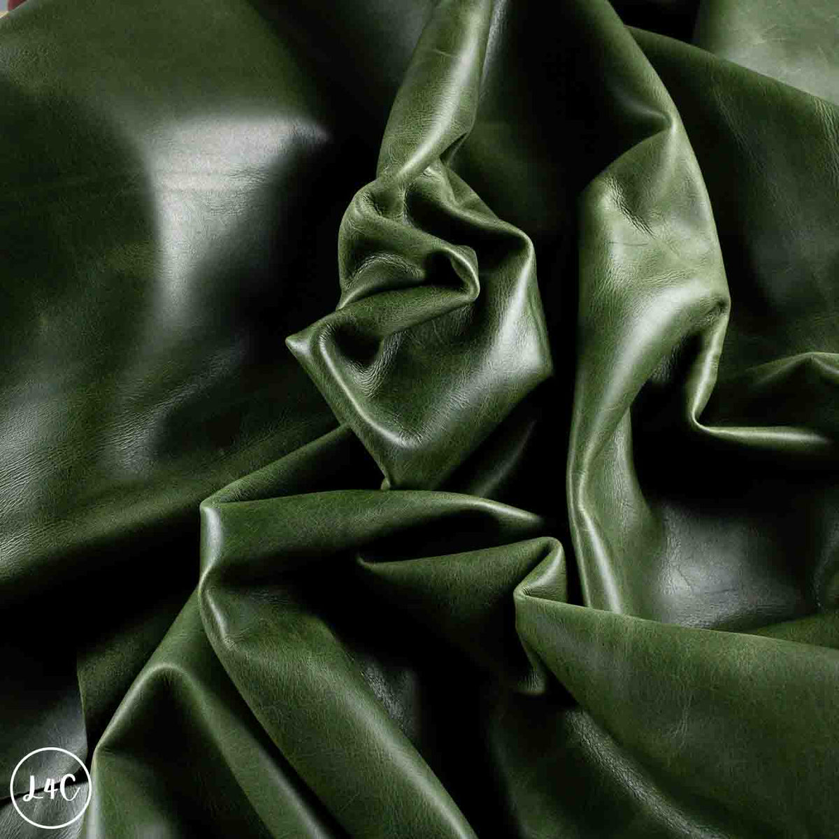Dark olive green leather draped in soft folds, showing a smooth texture and glossy sheen.
