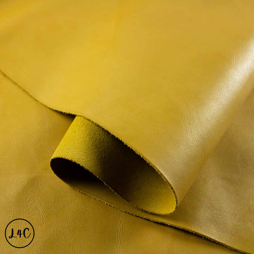 Close-up of yellow leather with a visible brand logo in the corner.