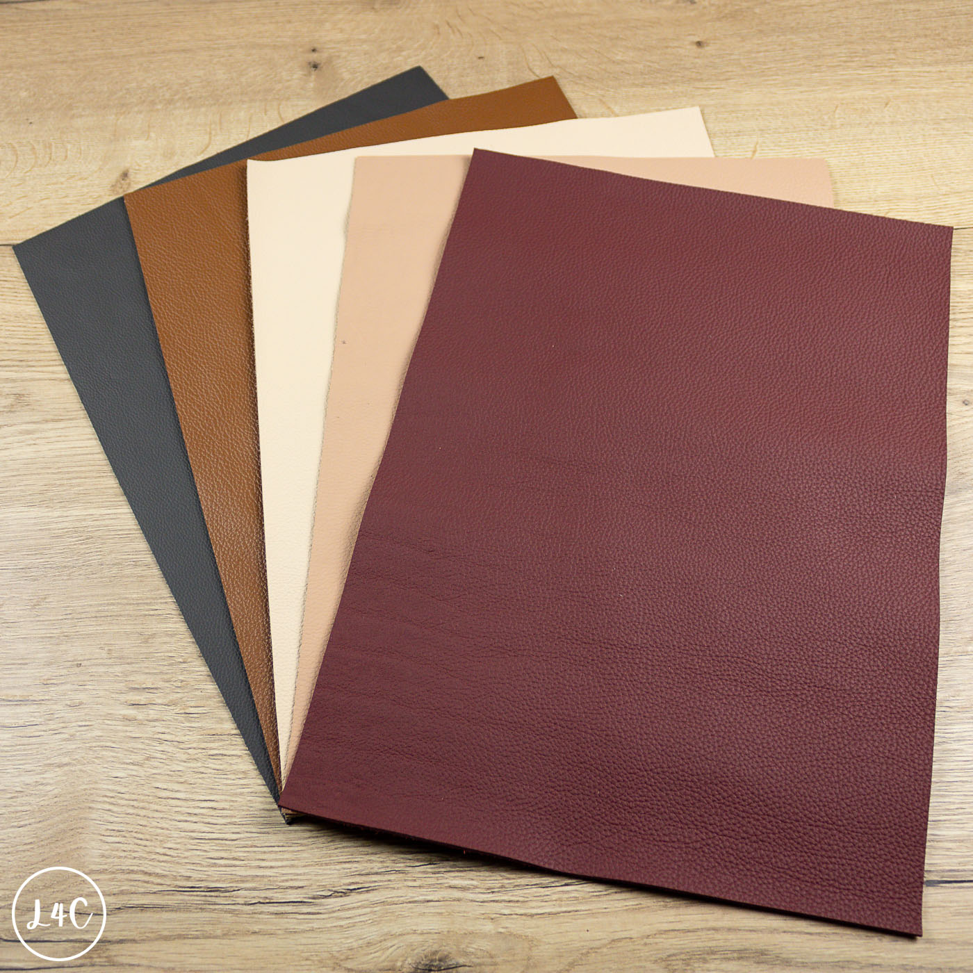 Set of leather samples in various colors on a wooden surface