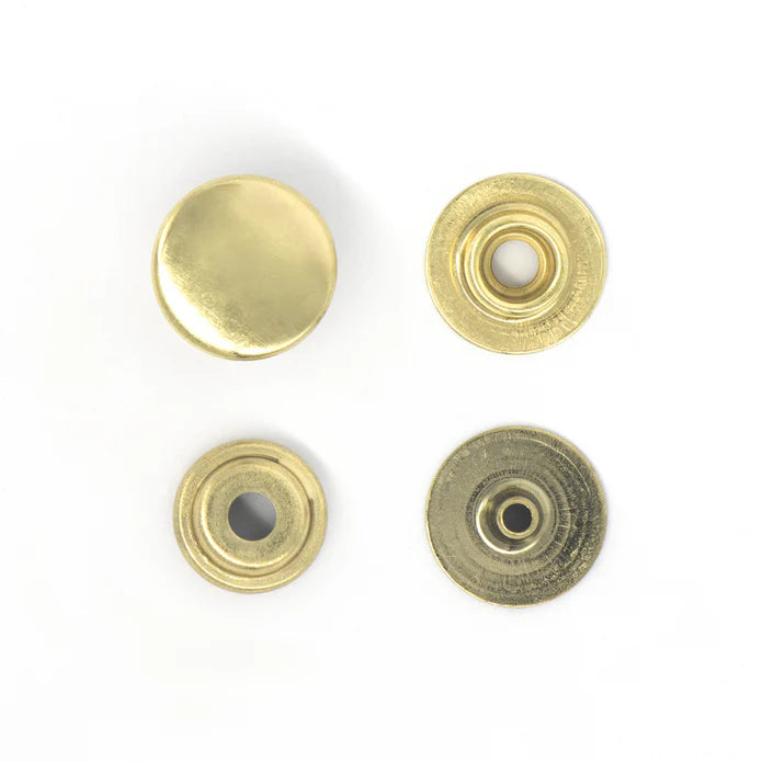 Four brass-colored metal components on a white background
