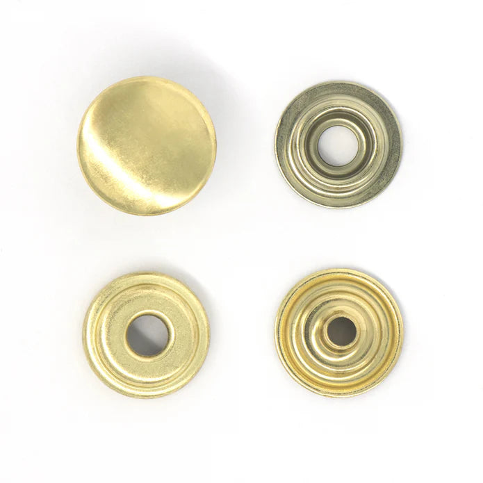 Four brass-colored metal buttons on a white background