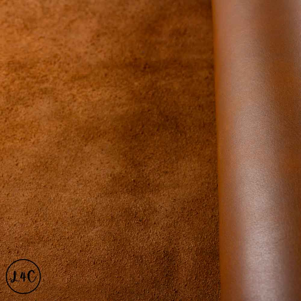 Close-up of brown leather texture with a visible brand logo in the corner showing consistent nap