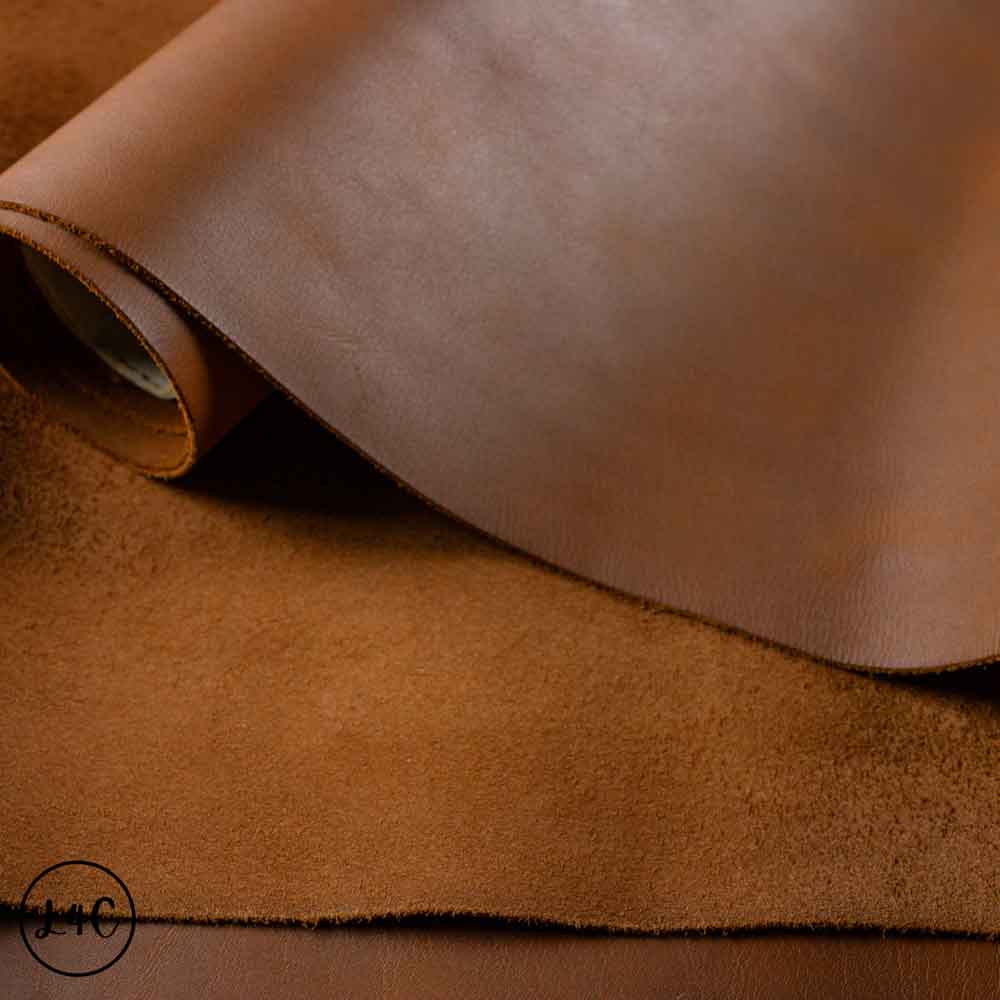 Close-up of brown leather fabric with a visible brand logo in the corner.