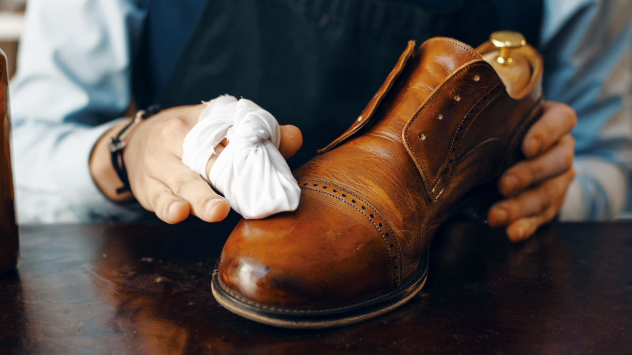 man cleaning leather shoe