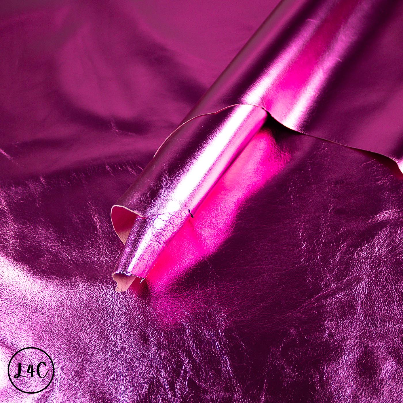 Close-up of a roll of pink metallic foil on a purple textured background