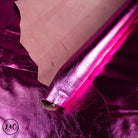 Close-up of pink metallic lamb skin with a visible brand logo in the corner.