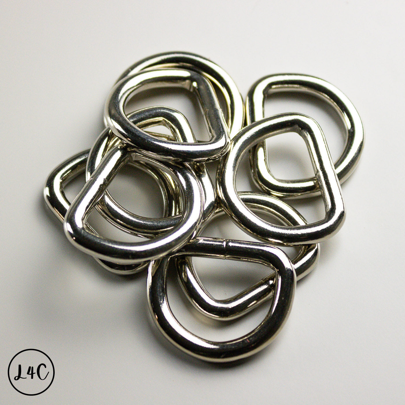 Stack of metal D-rings on a light gray background