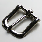 Metallic belt buckle on a light gray background