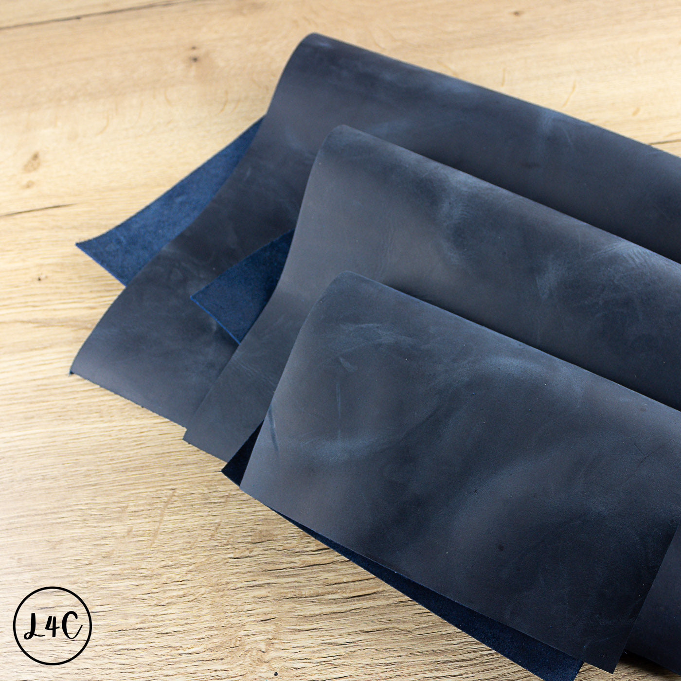 Dark blue crazy horse leather on a wooden surface