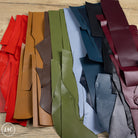 Collection of leather samples in various colors on a wooden surface