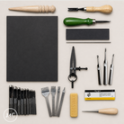 Collection of leatherworking tools and materials on a light beige background