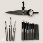 Set of metal tools including a wing divider and hole punch set and other instruments on a light background.