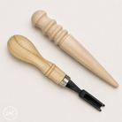 Two wooden tools with black accents on a light gray background