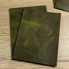 Two green leather panels on a wooden surface