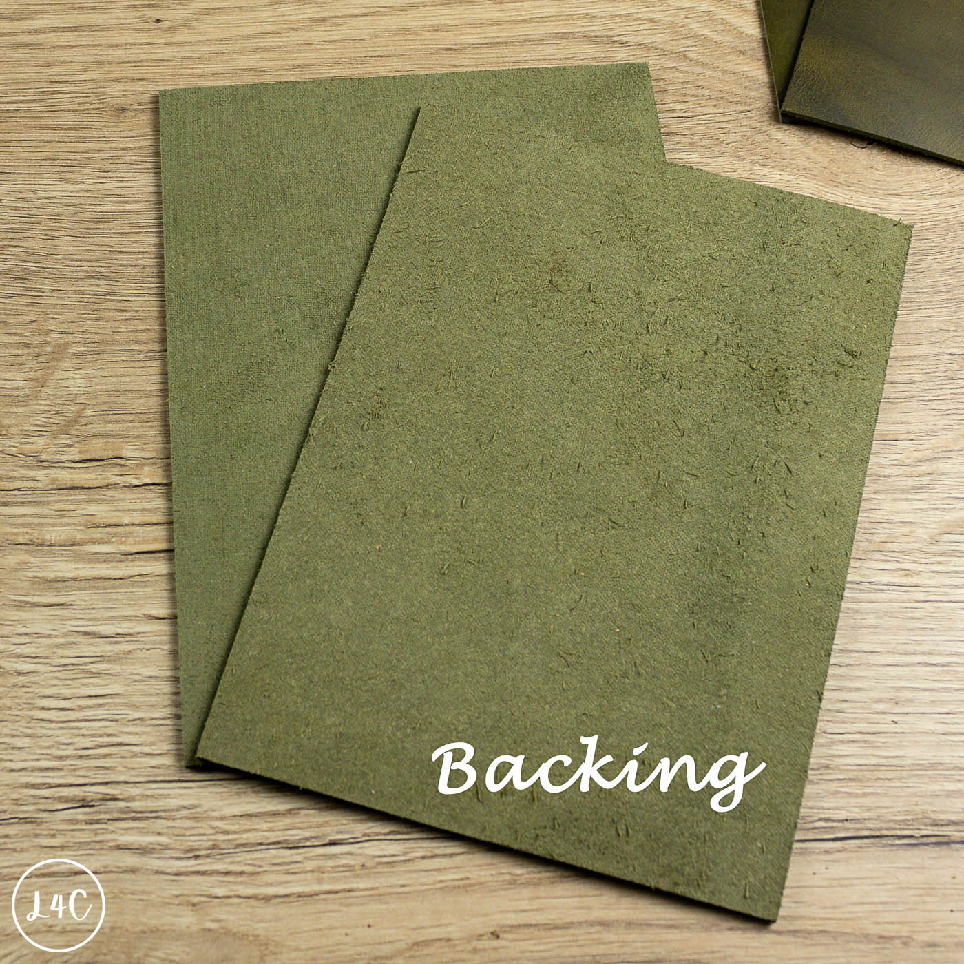 Two green country soft leather panels on a wooden surface with 'Backing' text.