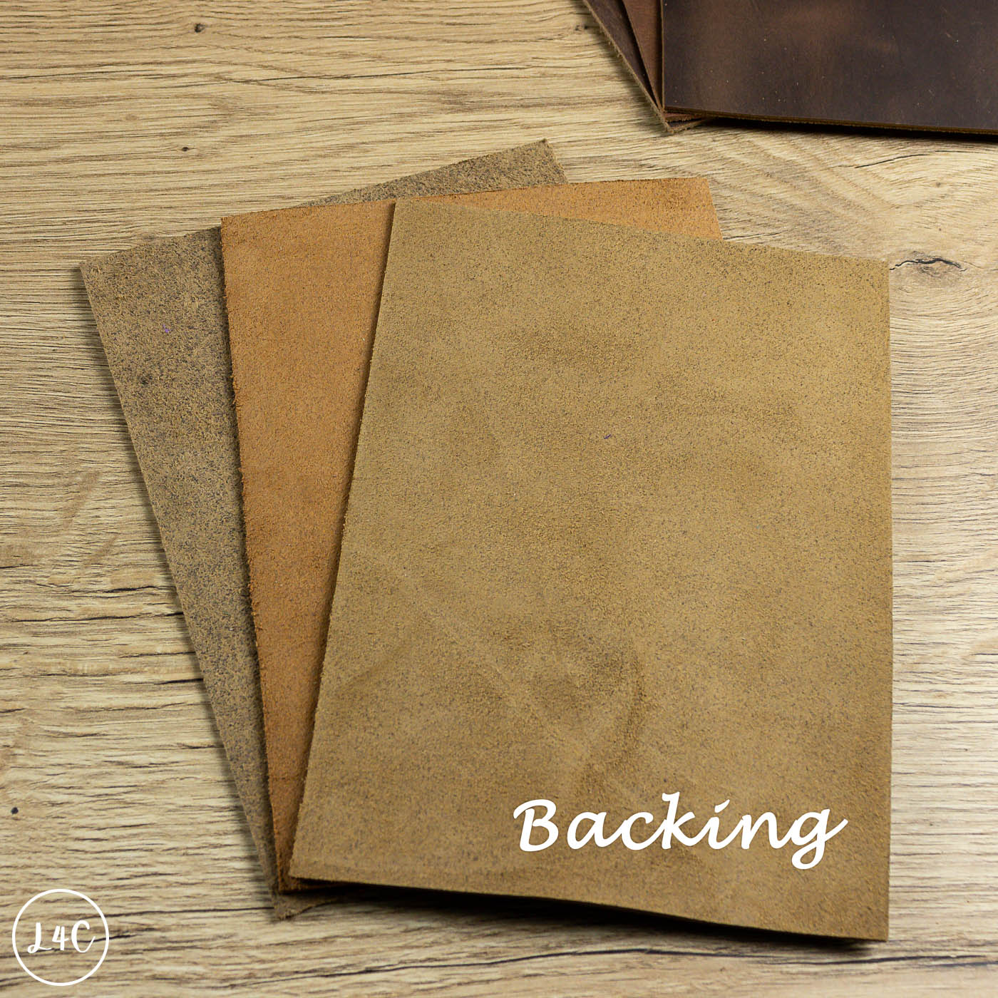 Three pieces of brown leather on a wooden surface with 'Backing' text.