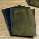 Three green leather panels on a wooden surface