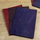 Three panels of purple leather panels on a wooden surface