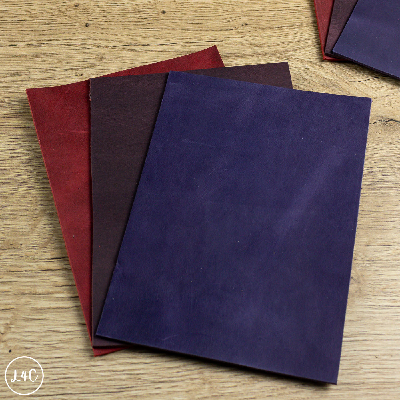 Three panels of purple leather panels on a wooden surface
