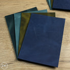 Set of country soft leather in various shades of blue and green on a wooden surface.