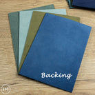 Stack of blue and green textured leather sheets on a wooden surface with 'Backing' text.