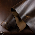 Brown leather hide with a subtle texture on a dark background