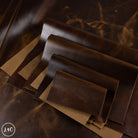 Stack of dark brown leather panels on a textured surface