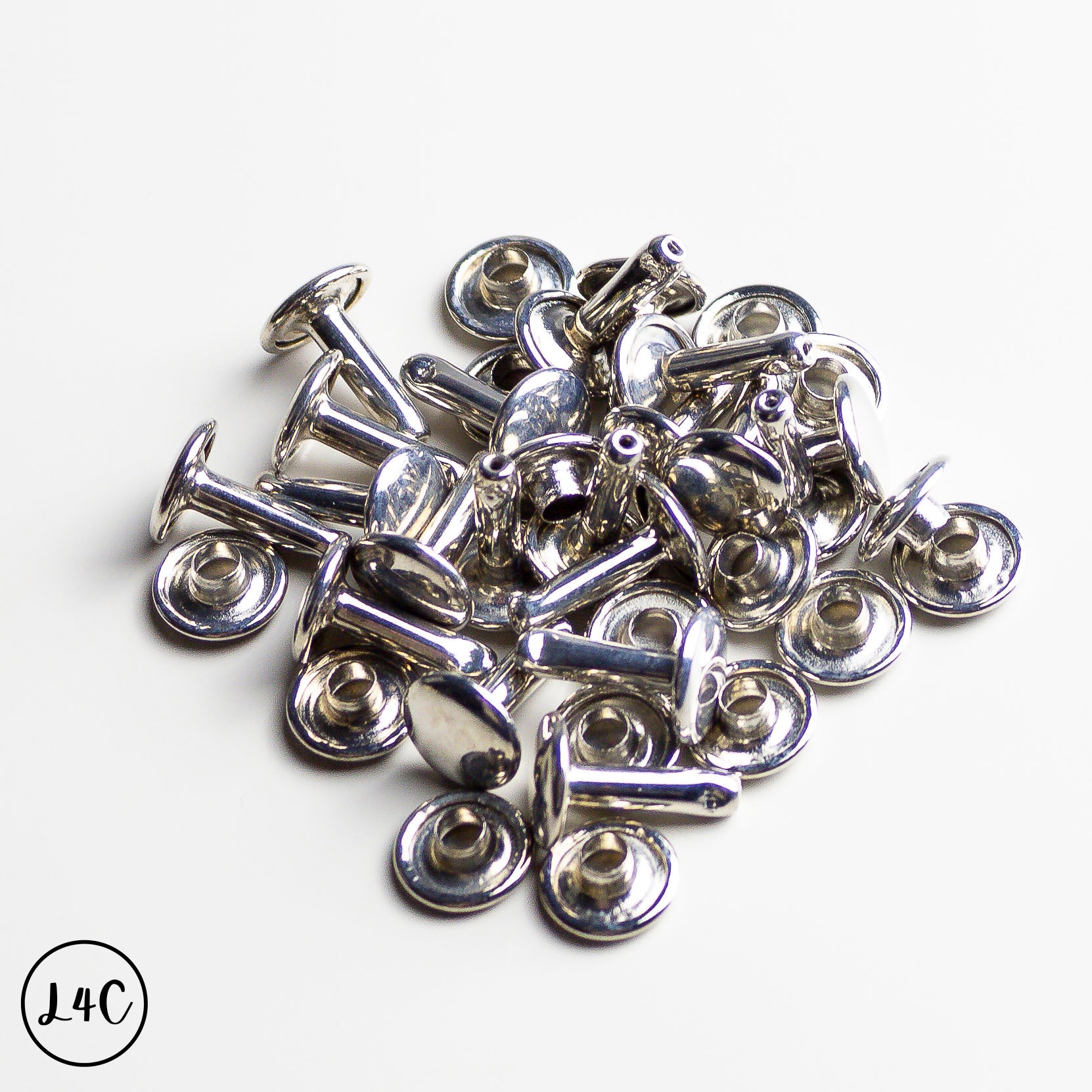 Collection of silver Double Cap Rivets on a white background