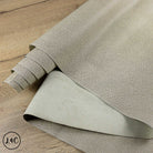 Roll of textured beige Tipped Epsom Grain Leather Hide on a wooden surface
