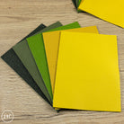 Collection of textured fairground leather panels in various colors on a wooden surface