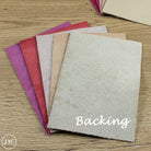 Collection of leather with 'Backing' text on a wooden surface